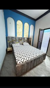 una camera da letto con un grande letto con pareti blu di Sanyiri meublée a Ouagadougou