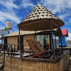 uma cabana com um telhado de palha e um banco em Q'OTA TAYPY LODGE em Puno