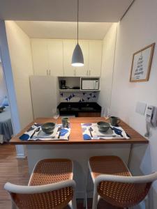 a kitchen with a table with two chairs and a kitchen with at Flat novo e equipado - Brasília/Sudoeste in Brasília +7 photos