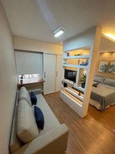 a living room with a couch and a bed at Flat novo e equipado - Brasília/Sudoeste in Brasília