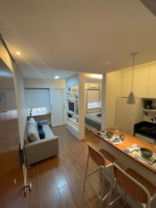 a living room and kitchen with a couch and a table at Flat novo e equipado - Brasília/Sudoeste in Brasília