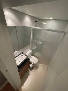 a bathroom with a sink and a toilet and a mirror at Flat novo e equipado - Brasília/Sudoeste in Brasília
