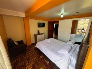 a bedroom with a large white bed and a chair at killa Anqas House in Cusco