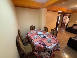 a dining room with a table with a red table cloth at killa Anqas House in Cusco