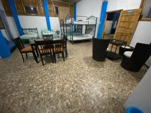 Zimmer mit einem Tisch, Stühlen und Etagenbetten in der Unterkunft Playa Aparts & Suites Malecon in Manta