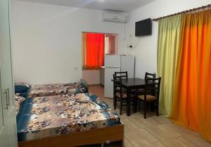 1 dormitorio con 1 cama y 1 mesa con sillas en Vila Muça, en Shëngjin