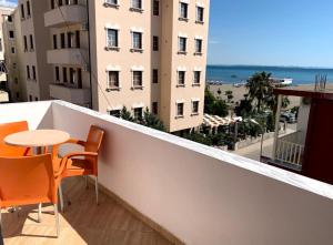 balcón con mesa y sillas y vistas a la playa en Vila Muça, en Shëngjin
