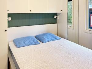 Hedensted - NordjyllandにあるHoliday Home Bævervejのベッド1台(上に青い枕2つ付)