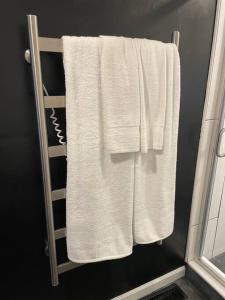 un toallero con toallas blancas en el baño en The Barn at Griffith Road, en Logan