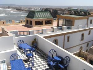 a balcony with blue tables and chairs on a building at Dar Al Bahar in Essaouira