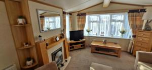 a living room with a fireplace and a television at Mollies Den in Ingoldmells