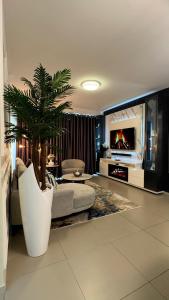 a living room with a couch and a palm tree at D&DLuxury Rivonia Apartments with inverter in Johannesburg