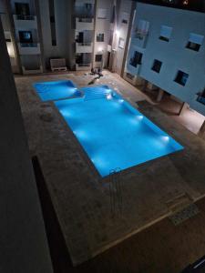 an overhead view of a large swimming pool at night at superb appartement in Kelibia