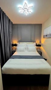 a bedroom with a large white bed with a chandelier at D&DLuxury Rivonia Apartments with inverter in Johannesburg