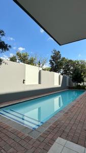 a swimming pool in the middle of a house at D&DLuxury Rivonia Apartments with inverter in Johannesburg
