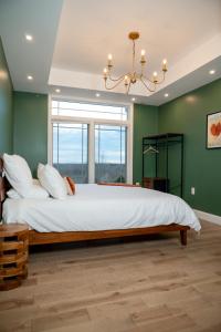 a bedroom with a large bed with green walls at New Farmhouse, King Beds, Game Room, Hot Tub & View! in Montgomery