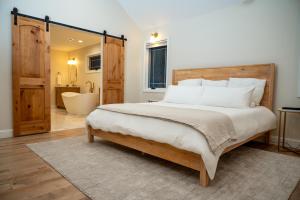 a bedroom with a large bed and a bathroom at New Farmhouse, King Beds, Game Room, Hot Tub & View! in Montgomery