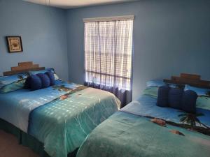um quarto com 2 camas e uma janela em Maggie's Cozy Corner em Wimauma