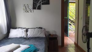 1 dormitorio con 1 cama con 2 almohadas en Tiny House Serendipia - Caserío El Puente -Villeta, en Villeta