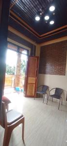 ein Zimmer mit zwei Bänken und einer Tür in einem Gebäude in der Unterkunft Toraja Bungin Homestay in Rantepao