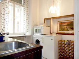 eine Küche mit einer Spüle und einer Mikrowelle in der Unterkunft Apartment Jakominiplatz in Graz