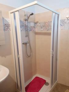 a shower with a red rug in a bathroom at Donna Concetta in Patti