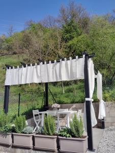 La casa di Ale في إندين جياناو: pergola مع طاولة وكراسي والنباتات