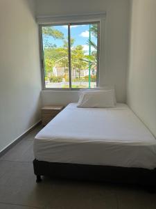 a bed in a room with a large window at Hotel Payara in Puerto Gaitán