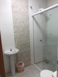 La salle de bains est pourvue d'une douche et d'un lavabo. dans l'établissement Casa em Atlântida Sul, com 2 quartos e 2 banheiros, com ar condicionado., à Xangri-lá