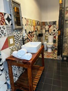 a bathroom with a sink and a toilet at Casa Columpio in Mexico City