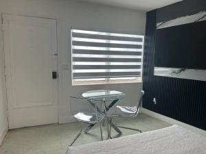 a table and a chair in a room with a window at VillaClara Studio-Little Havana in Miami