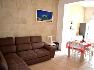 a living room with a couch and a table at Wabis two-room apartment on the ground floor in San Foca in San Foca