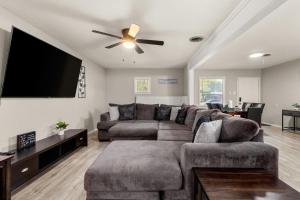 a living room with a couch and a flat screen tv at Cozy 3 bedroom with HOT TUB 2 min away from lackland in San Antonio