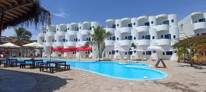 a hotel with a swimming pool in front of a building at Loki del Mar in Máncora
