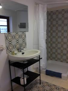 a bathroom with a white sink and a shower at La Cueva Soleá in Algodonales