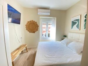 1 dormitorio con cama blanca y ventana en ESTUDIOS GRAN VÍA, en Madrid