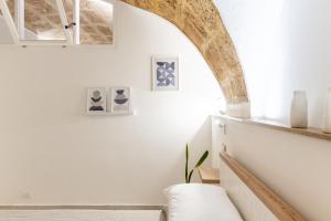 salon z białą kanapą i łukiem w obiekcie Sweet Hospitality - Apartments l Ferret24 w mieście Alghero