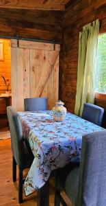 einen Esstisch mit Stühlen und einem Tischtuch in der Unterkunft Cabaña Los Cipreses in Tigre
