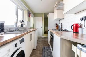 een keuken met witte kasten en een aanrecht bij Quiet & Cosy 3BedRoom - Great Base in South Shields near Hospital and Port of Tyne - Free Parking in South Shields