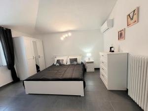 La casa di Ale في إندين جياناو: غرفة نوم بيضاء مع سرير وخزانة بيضاء