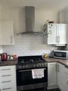 a kitchen with a black stove and a microwave at mid street in Bathgate