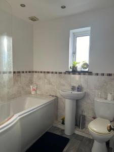 a bathroom with a tub and a toilet and a sink at mid street in Bathgate