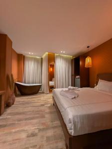 Almas Pyramids Hotel في القاهرة: غرفة في الفندق مع سرير وحوض استحمام