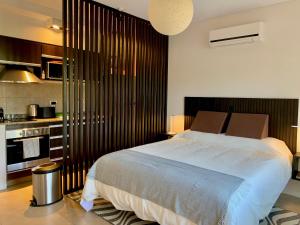 Un dormitorio con una cama grande y una cocina. en STAY @ Palermo Hollywood (Soler), en Buenos Aires