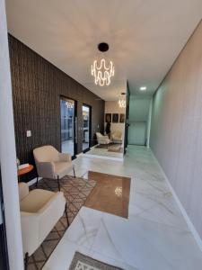 a lobby with chairs and a chandelier at Flat Home Business 303 Centro de Pomerode in Pomerode