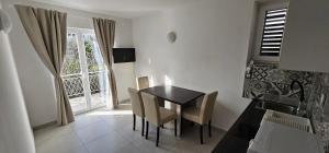 a dining room with a table and chairs and a window at Apartment Buco in Starigrad