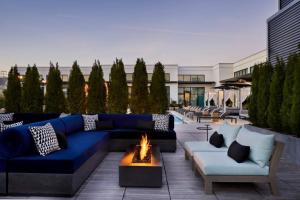 亞特蘭大的住宿－Cozy Sophisticated Stay 1Bed 1Bath! Luxurious Pool, Fitness, Coffeehouse & more!，一个带蓝色沙发和火坑的庭院
