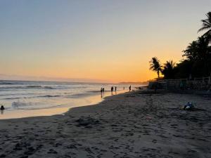 a group of people walking on the beach at sunset at Brisas del Mar in La Libertad