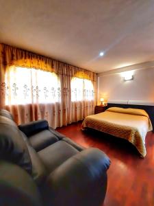 una camera con un letto, un divano e un letto di Villa Valcore a Mérida