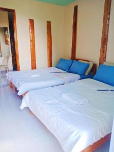 drie bedden in een kamer met blauwe en witte lakens bij Aesthetic Infused with Rustic Vibe Rooms at BOONE'S in Sagada